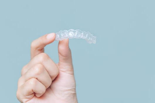 Man holding invisalign brace Man holding invisalign brace