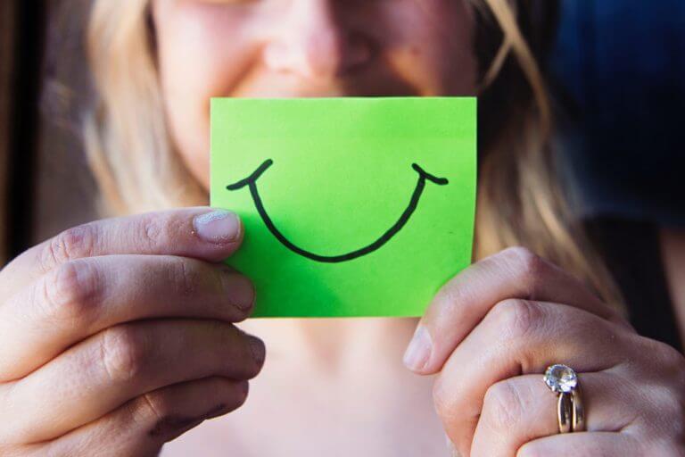 woman-holding-a-paper-with-a-smile woman-holding-a-paper-with-a-smile