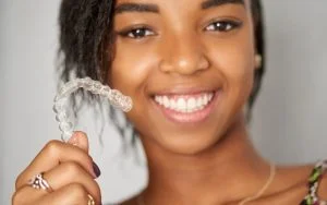 African woman holding Invisalign